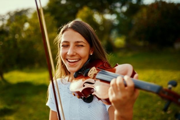 Woman playing the violin and smiling