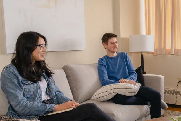 Photo of two grad students sitting in a living room