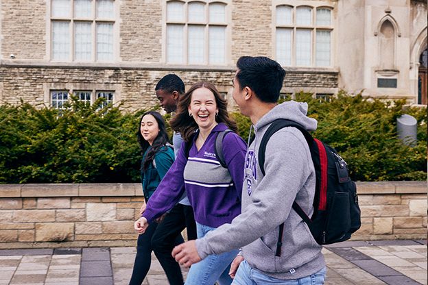 A group of people walking outside a building.